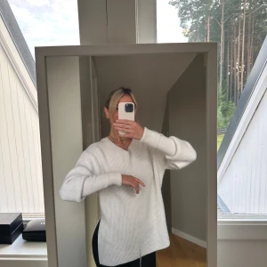 Vit stickad tröja - Säljer en supermysig vit stickad tröja som är perfekt för kyliga dagar. Den har en normal passform och långa ärmar med ribbade muddar. Tröjan är enkel men stilren och passar till det mesta. Perfekt för både höst och vinter!