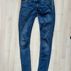 Tiger of Sweden jeans - Jeans i klassisk blå från tiger of Sweden i storlek 29/32. Använda fåtal gånger men fått liten lätt missfärgning i på baksidans märke av TJ (se bild) annars i bra skick. 