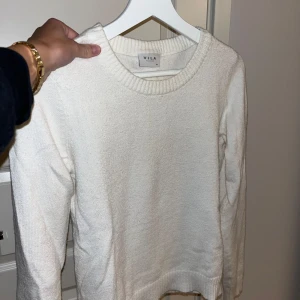 Vit stickad tröja från Vila - Säljer en superfin vit stickad tröja från Vila. Den är perfekt för både höst och vinter med sin mysiga och varma känsla. Tröjan har långa ärmar och en klassisk rund halsringning. Passar perfekt till både jeans och kjol för en stilren look!