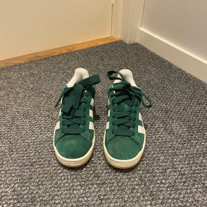 Adidas campus  - Säljer dessa gröna adidas campus 00, köpta i våras för ungefär 1300kr. Använda max 2-3 gånger, väldigt fint skick. Tre olika snören medföljer, samt storlek 40 för kvinnor. Hör av er för frågor eller bilder! 💞