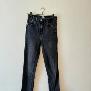 Svarta jeans från Zara - Säljer ett par snygga svarta jeans från Zara. De är högmidjade och har en klassisk femficksdesign med knapp och dragkedja fram. Perfekta för både vardag och fest!