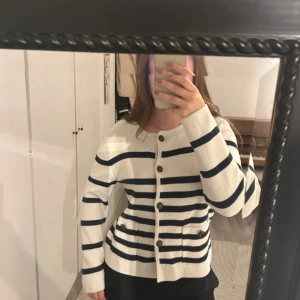 Randig stickad kofta - Randig stickad kofta med knappar från Flash Woman. Använt några gånger. Storleken passar allt ifrån XS-L. Färger är vit och marinblå.