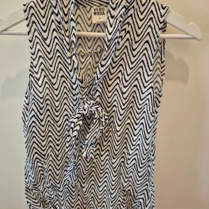 Topp Vero Moda - Mönstrad topp men knut från Vero Moda. Använd fåtal gånger. Skön och lätt material. Storlek XS. 100% viskos. 