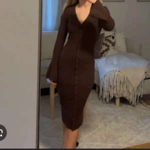 Bakbok brun klänning  - LÅNAD BILD! Säljer min superfina bikbok klänning i brun med knappar. Den är lång och superstretchig med vida armar. Den är i storlek Xs men passar XS-M då den är väl drift stretchig😊🫶🏼