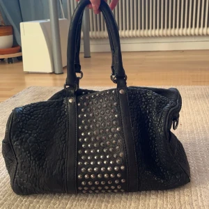 Väska - En fin svart väska. Aldrig använd, köpt från secondhandbutik. 30 cm i längd och 20 cm i höjd.