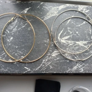 Öronhängen  - Säljer två par öronhängen, ett par guldiga och ett par silvriga, båda är nya! säljer en för 40kr eller båda för 70! 