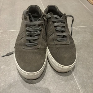 Axel Arigato strl 41 - Riktigt fina grå Axel Arigato i storlek 41.  Knappt använda men tyvärr en svart fläck på sulan (se sista bilden) som jag ej får bort. Övligt i nyskick. 