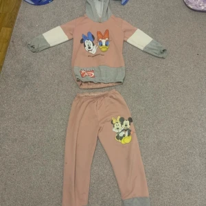 Rosa mickey mouse set för barn - Jag säljer en rosa mickey mouse set för barn som är med en ritning av mickey mouse på byxorna och hoodie. Den är skön och varm och jette snygg för barn. Den passar för barn som är 10,9 år eller yngre