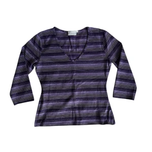 Lila randig topp - Snygg lila randig topp med v-ringning och trekvartsärmar. Perfekt för en stilren look.