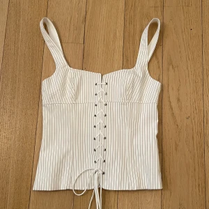 Vit randig korsett från Zara - Säljer denna skit snygga korsett topp från zara! Den är jätte snygg och eftersökt. Den är aldrig andvänd så i helt nytt skick!!❤️❤️