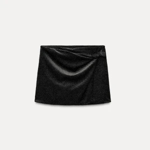 Svart glittrig kortkjol med shorts  - Snygg svart kortkjol med glittrigt mönster och en elegant drapering framtill den har dessutom har den  inbyggda shorts.Den är i storlek M helt ny med prislappen kvar.  💗säljer för att den passar inte mig så jag kan inte skicka bilder med den på men jag kan skicka bilder på bara kjolen 😊💗