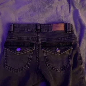 Svarta jeans från gina tricot - Snygga svarta jeans från gina tricot men köpte på nelly med klassisk femficksdesign och knappstängning. De har en lågmidjad passform och raka ben, vilket ger en tidlös look. Perfekta för en avslappnad stil.