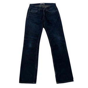 Mörkblå jeans från Acne - Snygga mörkblå jeans från Acne med klassisk femficksdesign och dragkedja. Perfekta för en stilren look. De har en rak passform som ger en tidlös stil.