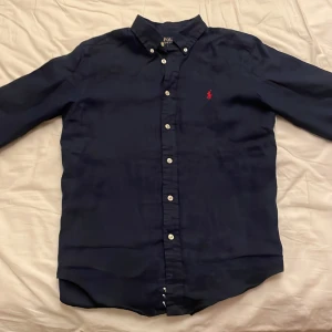 Skjorta Polo Ralph Lauren - Tja säljer denna linne skjorta Polo Ralph Lauren. Skicket är i 9/10 och inga slitningar. Storlek är 14-16 år men passar perfekt 164. Pris kan diskuteras vid snabb affär. Hör gärna av dig vid mer frågor😊