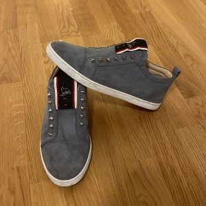 Grå sneakers från Christian Louboutin - Säljer min killes gråa sneakers från Christian Louboutin. Det fattas en nit, men bortsett från det är dom i princip helt oanvända. Hör gärna av er för fler bilder! ⭐️ Skorna har ingen sula 