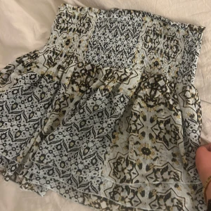 Mönstrad kjol från Lindex - Säljer en mönstrad kjol från Lindex i storlek M. Kjolen har ett elastiskt midjeband och ett vackert mönster i svart, vitt, beige och liten liten hint av ljusgrön. Perfekt för sommaren!!💞