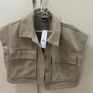 Beige väst från Gina Tricot - Aldrig använd, fick 2 stycken samma så jag säljer en ordinarie priset var 379kr men säljer för 200kr 