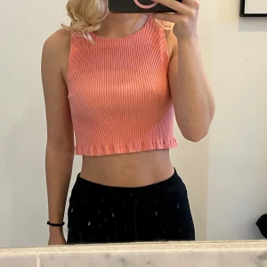 Rosa ribbad croppad linnetopp - Säljer en söt rosa ribbad linnetopp från Zara. Toppen är croppad och ärmlös, perfekt för varma dagar. Den har en enkel och stilren design som passar till många olika outfits.