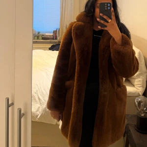 Brun pälsjacka - Säljer en lyxig brun pälsjacka med långärmad design. Jackan har en elegant och mjuk finish som ger en exklusiv känsla. Perfekt för att hålla sig varm och stilren under kyliga dagar.