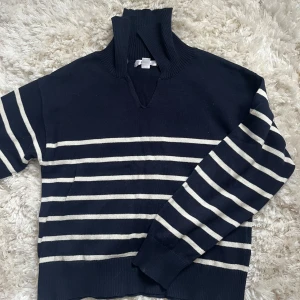 Marinblå randig tröja från Gina Young  - Säljer en snygg marinblå tröja med vita ränder från Gina Young. , perfekt för kyligare dagar. Den är tillverkad i ett mjukt material.