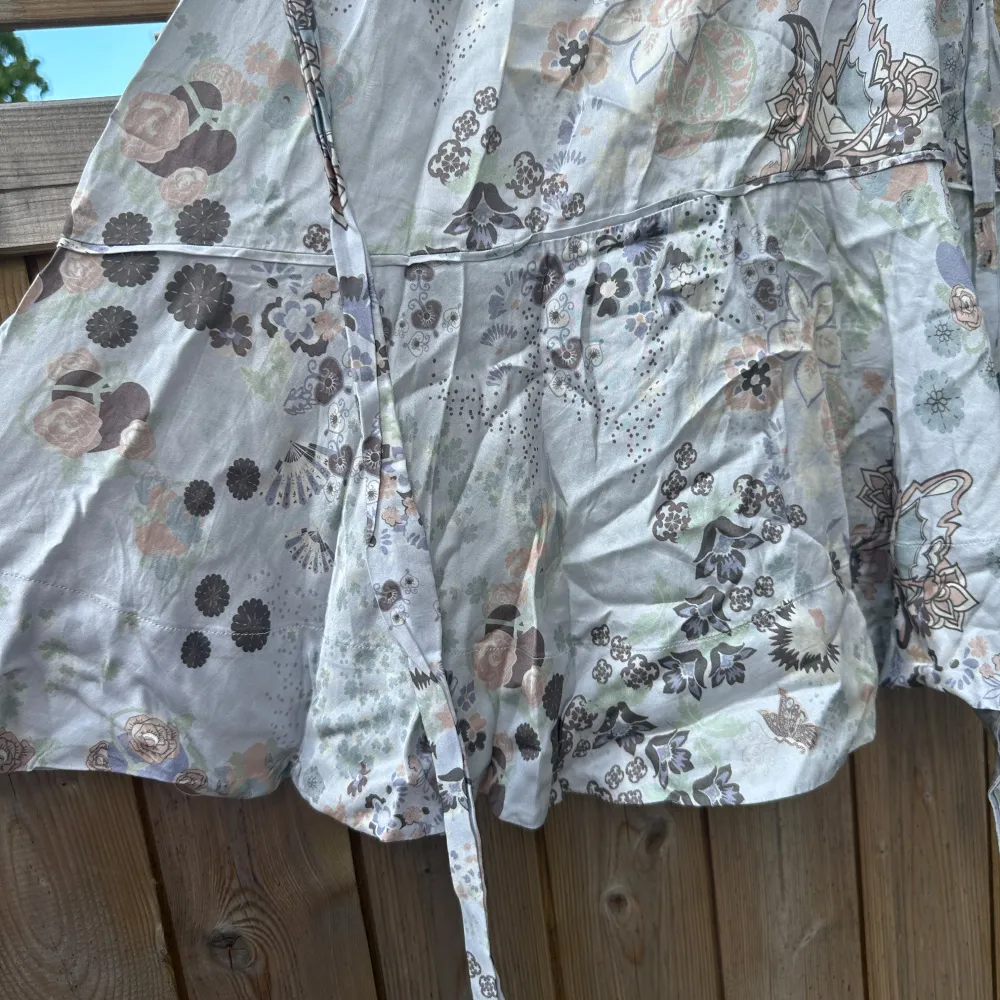 Charmig kortkjol med blommigt mönster i ljusa toner. Kjolen har knytband i midjan och en luftig passform som ger en avslappnad look. Perfekt för varma dagar.Från märket Odd Molly i storlek 0 som enligt deras storleksguide motsvarar en storlek XS. Mycket fint skick, jag hittar inga synliga anmärkningar eller defekter. . Hameet.