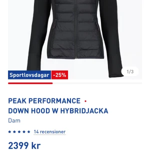 Svart hybridjacka från Peak Performance - Snygg svart hybridjacka från Peak Performance med dunfyllda paneler och långärmad design. Perfekt för kyliga dagar med en stilren look. Jackan har en dragkedja framtill och är idealisk för både stad och natur.