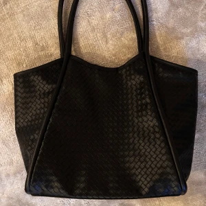 Svart flätad väska  - Jättesnygg stor svart flätad väska från ASOS. Perfekt till skolan för att få med allt du behöver. Den får plats med dator, böcker, ja allt! Bild visas för referens!