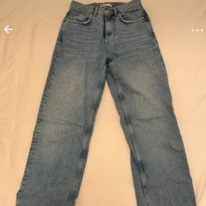 Blå jeans med slits - Jättefina blå jeans från Gina Tricot med hög midja och rak passform samt en snygg slit längst ner. Endast använda fåtal gånger!