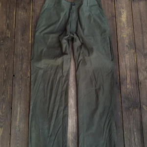 Gröna byxor  - Säljer ett par gröna byxor. De har en rak passform och är tillverkade i ett slitstarkt material. Perfekta för en avslappnad stil. Byxorna har fickor i låren, se bild.