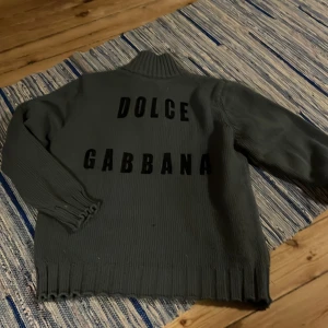 stickad tröja från Dolce & Gabbana - Snygg stickad tröja från Dolce & Gabbana med text på ryggen. Storlek m och skulle passa både tjej och kille. Mysig och ha på sidreda😊