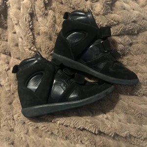 Svarta sneakers från Isabel Marant - Snygga svarta sneakers från Isabel Marant med kardborreband och hög design. Skorna är i mycket bra skick, endast använda 4g. För även om jag mer än gärna vill, så passar inte skorna mig. Nu söker skorna en värdig ägare 👠😀