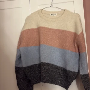 Randig tröja från H&M - Säljer en mysig randig tröja från H&M i flera färger: beige, rosa, blå och svart. Tröjan har en rund halsringning och långa ärmar. Perfekt för kyligare dagar!