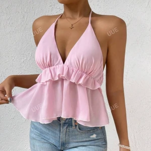 Rosa halterneck topp - Säljer en söt rosa halterneck topp med volangdetaljer. Toppen har en djup v-ringning och knytning i nacken. Perfekt för varma sommardagar.