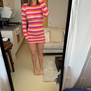 Färgglad klänning  - Färgglad kort klänning ifrån Bershka med öppen rygg i storlek M och vida armar.  Helt oanvänd. Skönt stretchigt material. 