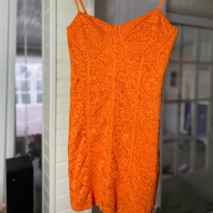 Orange spetsklänning - Säljer en superfin orange klänning i spetsmaterial. Passform som verkligen framhäver figuren. Perfekt för sommarens fester eller en utekväll med vänner. Klänningen är kort och har en härlig, livfull färg🧡