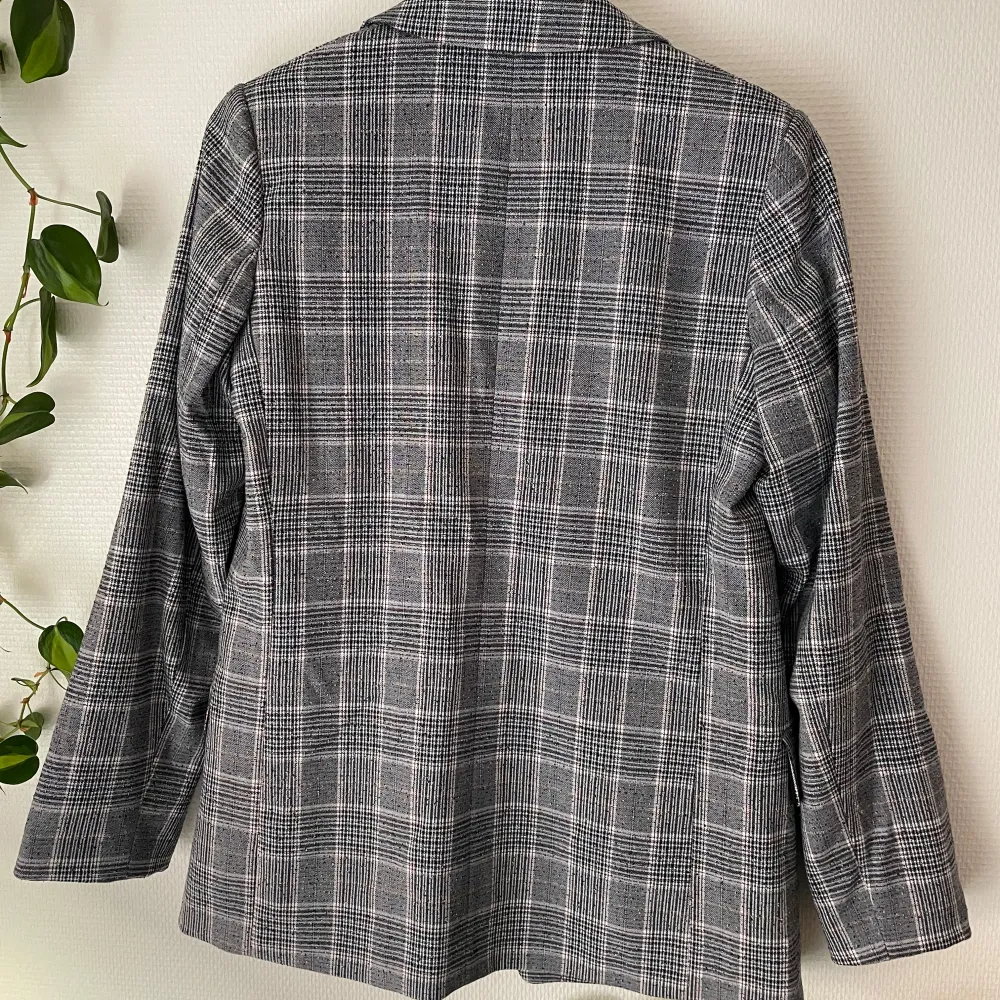 Säljer en snygg rutig kavaj från H&M i storlek 38. Den har en klassisk svart och vit rutig design med långa ärmar och en stilren passform. Perfekt för både vardag och festliga tillfällen!. Takit.