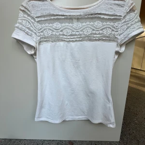 T-shirt med spets - Jättefin T-shirt med spets högst upp, den har en lite fläck mitt på men jag tror det gör bort i tvätten. Skriv om du har frågor💕💕