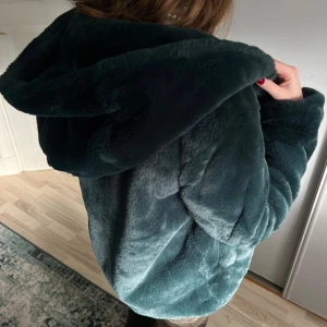 Pälsjacka  - Så gosig grön pälsjacka med stor luva. Köpt i london och tror märket är stradivarius men är inte helt 100. 