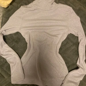 Silver glitter tröja - Jag säljer en silvrig glitter tröja med en turtle neck. 