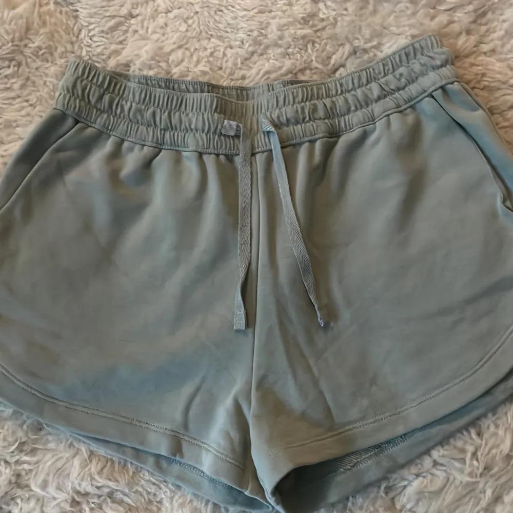 Säljer ett par bekväma grå shorts från H&M i storlek S. De har en elastisk midja med snörning för perfekt passform. Perfekta för en avslappnad dag hemma eller en promenad i parken. 🩶. Shorts.