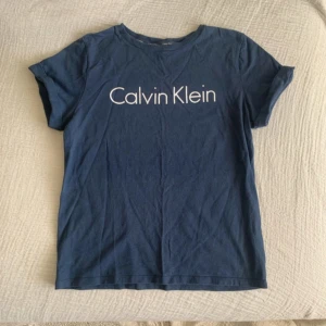 Calvin Klein T-shirt  - Marinblå Calvin Klein tshirt i fint skick söt detalj med en vikning på ärmarna. 