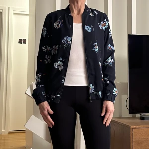 Tunn blommig jacka - Marinblå tunn blommig jacka från Kappahl. Strl xs, använd men mycket fint skick