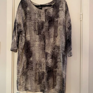 Beige/grå/svart kortare klänning i strl 40 från Part two - Beige/grå/svart kortare klänning i strl 40 från Part two.  Sparsamt använd och i fint begagnat skick.  Mått Över bröstet: ca 60 cm Längd från axeln och ner: ca 87 cm  Tyvärr har jag klippt bort lappen i sidan så jag vet inte vilket material den är i.