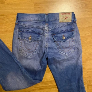 True religion jeans - Så fina jeans i unik färg/stygn men kommer tyvärr inte till användning! Skriv om ni har några fler frågor. Midjemått över: ca 41 cm Benlängd: ca 84 cm