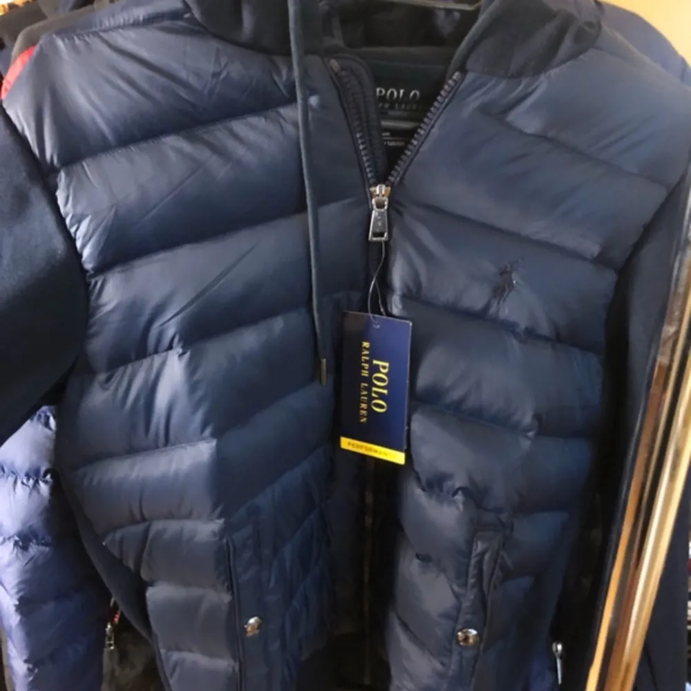 Säljer en snygg blå dunjacka från Polo Ralph Lauren i storlek XS. Jackan har en dragkedja och en huva, perfekt för kyliga dagar. Den är i nyskick och har en stilren design som passar både till vardags och fest. Perfekt för höst och vinter! Skick:10/10. Jackor.