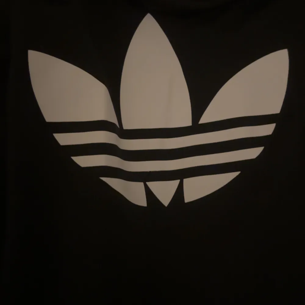 Säljer en svart Adidas träningsjacka i storlek XS. Den har de klassiska vita ränderna längs ärmarna och en dragkedja framtill. Perfekt för träning eller som en snygg vardagsjacka. Adidas-loggan syns både fram och bak. Skön och stilren design!. Jackor.