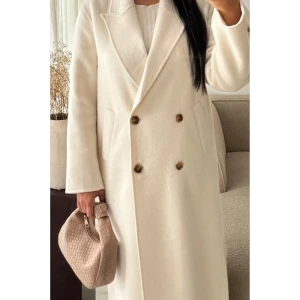 Vit lång kappa - Helt ny med prislapp! Fast pris! Inget fel på den utan passar ej i ljusa färger, behöll bara den svarta.  - fin  -lång 134 cm - varm (50% ull 40% polyester 10% autres fibres) -storlek L (passar upp till en 44)