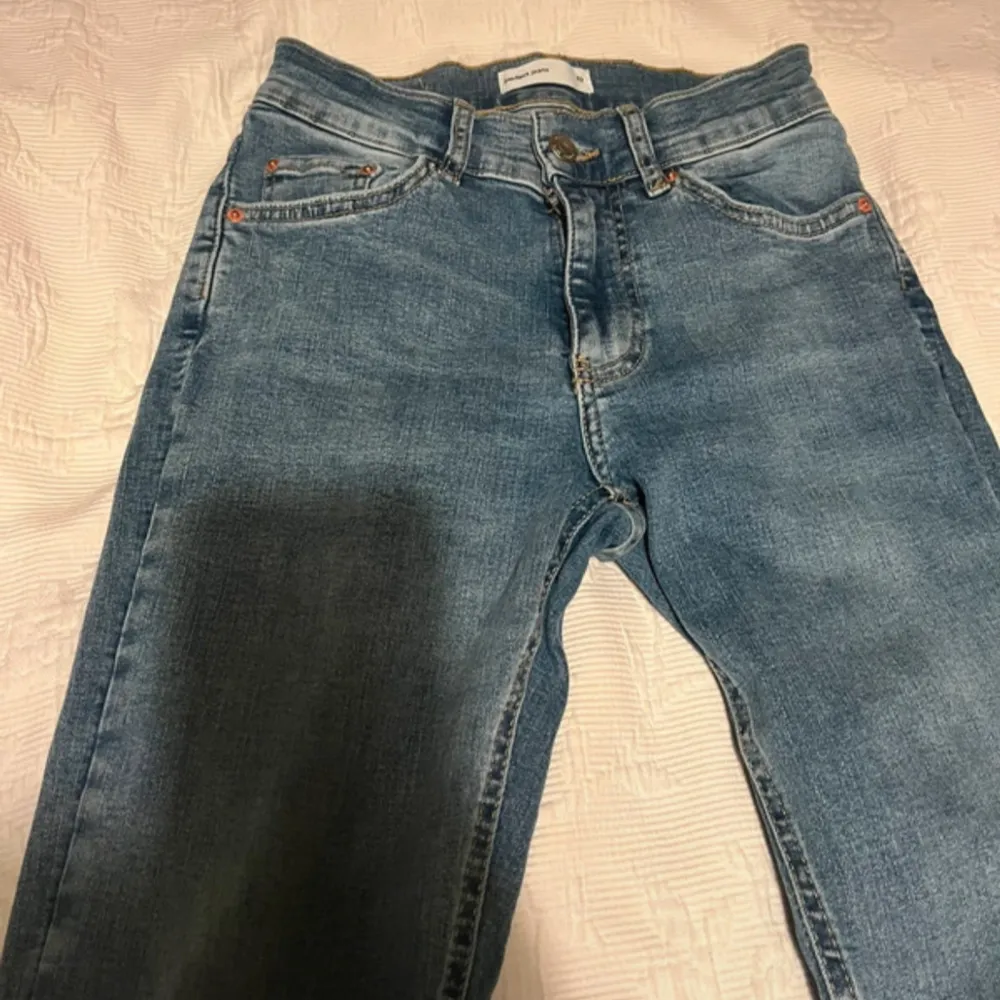 Säljer ett par klassiska blå jeans med bootcut-stil. De är i bra skick och har en snygg tvätt som passar perfekt till vardags. Jeansen har en knapp och dragkedja framtill samt fem fickor. Perfekta för både höst och vår!. Jeans & Byxor.