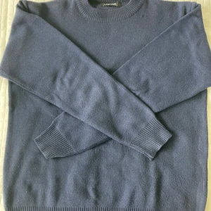 Mörkblå tröja från Lanzans - Säljer en stilren mörkblå tröja från Lanzans i storlek L men passar S egentligen. Tröjan är stickad och har långa ärmar med ribbade muddar vid ärmslut och nederkant. Perfekt för höst och vinter, både varm och bekväm. Passar till både vardag och lite finare tillfällen. 🧥