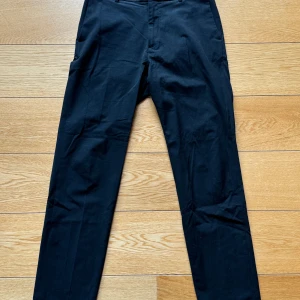 Svarta byxor från HM – Storlek 31 - Svarta byxor från HM i storlek 31, i fint skick. Ett stilrent och mångsidigt plagg som passar till både vardag och mer uppklädda tillfällen.